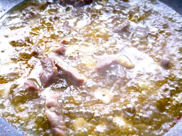 咸牛肉在沸腾的油煎 这是在银锅 — 图库照片