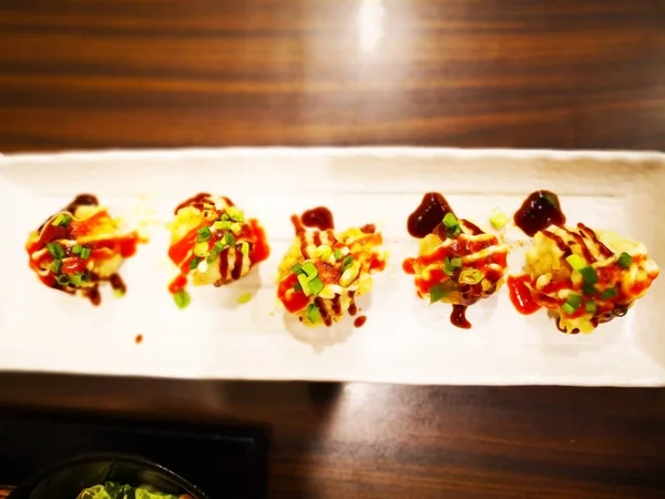 Gıda, Takoyaki Japon atıştırmak un, patatesten yapılan şal ahtapot parçalarını içeren küçük yuvarlak toplar şeklinde bir kavramdır. Beyaz plaka vardır. Seçici odak ve kopya alanı.