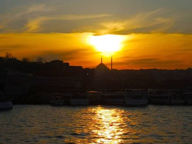 Istanbul, Türkiye-Mart 30, 2018: Güneş Istanbul içi Galata Köprüsü yakınlarında dock camide arkasında gökten yağan.