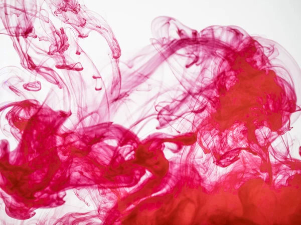 Proceso de disolver tinta acrílica en agua. Increíble fondo abstracto. Salpicadura de pintura colorida fotografiada mientras está en movimiento. Nube acrílica en líquido. Gotita de disipación de color rojo en líquido . — Foto de Stock