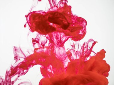 Splash altında kırmızı akrilik mürekkep su üzerinde izole beyaz arka plan. Kırmızı mürekkep suya düştü ve hareket ederken fotoğraflandı. Görüntü boya su donmuş kırmızı renkli akışının.