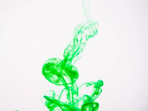 水のグリーン ペイントのスプラッシュ。アクリル インクの液滴の液にし溶解しながら撮影します。カラフルな緑色のペンキは、白い背景で隔離。インクが水に溶解. — ストック写真