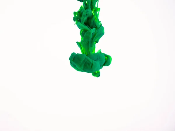 Σταγόνα ακρυλικό χρώμα πράσινο ριφθεί στο νερό που απομονώνονται σε λευκό φόντο. Πράσινο μελάνι σε νερό, αφηρημένα φόντο. Χρώμα πράσινο πέσει στο υγρό. Μελάνι χρώματος που φωτογραφήθηκε ενώ σε κίνηση. — Φωτογραφία Αρχείου