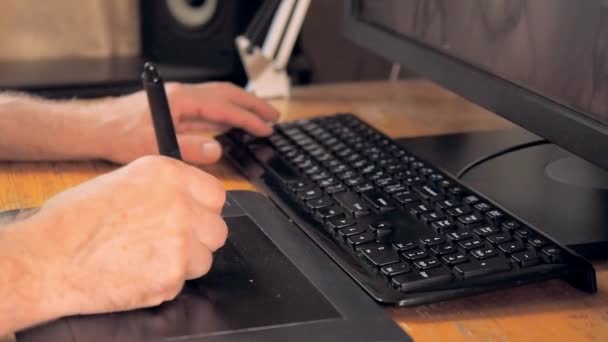graphic designer drawing on tablet computer with digital pen close up view mans hand using touch screen pen and black keyboard man at work on tablet pc blurred background soft selective focus