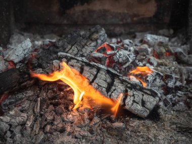 Yanan ateş, görünümü kadar yakın. Parlayan köz ile portakal alev yanan. Sebze Bahçe geceleri yanan şömine. Doku köz yanma. Arka plan bulanık. Yumuşak seçici odak.