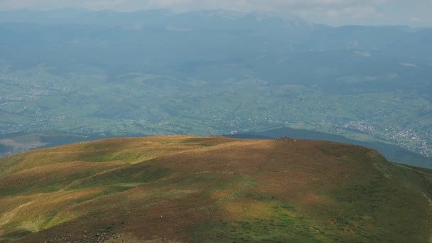 夏のカルパティア山脈。極端なロング ショット。羊の群れが放牧します。山の頂は白い雲で覆われています。ウクライナの自然風景。背景をぼかした写真. — ストック動画