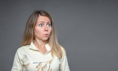 Kadın duygu. Akan ile fena halde şaşırttı, şaşırmış gibi bir kadın sarışın saç. Tarafına bakarak yuvarlak ve şişkin gözlü kız. Stüdyoda çekim gri arka plan üzerinde duygusal kadın portresi