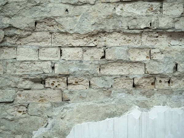 Close up view on brickwall with peeled off white plaster. Ancient brickwall background. An old ruined wall texture. Grey vintage masonry surface. — Stock Photo, Image