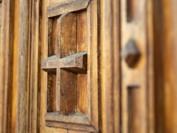 Frammento di porta di legno marrone nel monastero, vista da vicino. Porta con croce e sculture decorative. Antica porta in legno nel monastero, Ucraina. Cancello decorato. Sfondo sfocato. Focus selettivo morbido . — Foto Stock