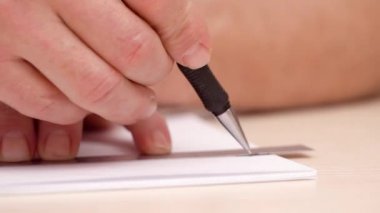 Beyaz boş çizgi çizmeyi sanatçı. Yakın çekim. Yan görünümü. Eller fırça kalemi ve cetvel çizgi çizmeyi mans. İnkpot bej masasında. Kaligrafi yazı. Seçici yumuşak odak. Arka plan bulanık.