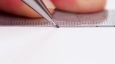 Fırça kalem ve demir cetvel ile bir çizgi çekerek calligraphist. Kaligrafi yazı için hazırlanıyor. Yakın çekim. Yan görünümü. Çizim beyaz boş satırda dostum. Seçici yumuşak odak. Arka plan bulanık.