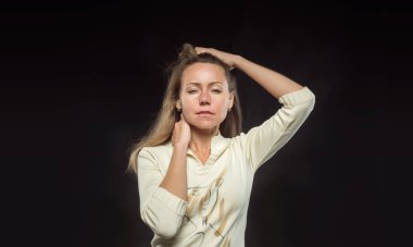 Sarışın genç kadın el baş ve daralmış gözleri kadar ileri mesafe içine baktı. Siyah arka planda etkileyici fotoğraf yüz ifadeleri ve jestleri rüzgarda çırpınan saçlı kız