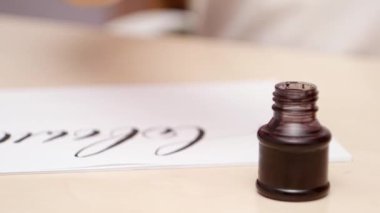 El koyar fırça kalem inkpot ve beyaz boş çizim harfleri mans. Yakın çekim. Önden Görünüm. Kaligrafi yazı. Beyaz boş yazma calligraphist. Seçici yumuşak odak. Arka plan bulanık.