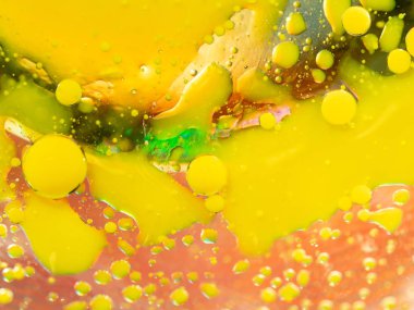 Multicolour arka plan üzerinde sarı boya su sıçramalarına. Atış makroyu kapatın. Arka plan bulanık. Seçici yumuşak odak. Multicolour boya damla ve noktalar soyut desen.