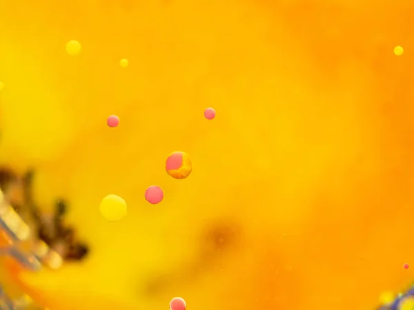 Yellow and pink bubbles in abstract universe. Close up macro shot. Blurred background. Selective soft focus. Orange abstract space with yellow and pink spheres, abstract orange pattern.