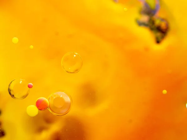 抽象的なオレンジ色の背景に黄色、ピンク、透明な球体。マクロショットを閉じます。ぼやけた背景。選択的ソフトフォーカス。オレンジ抽象宇宙。宇宙の泡. — ストック写真