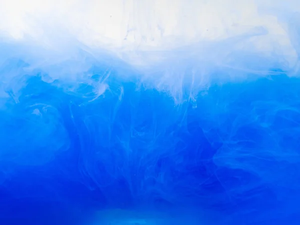 Pittura blu disciolta in acqua, vista da vicino. Sfondo astratto. Modello astratto di inchiostro che si dissolve in acqua. Vernice acrilica vorticosa in liquido. Goccia d'inchiostro in liquido. Sfondo sfocato . — Foto Stock