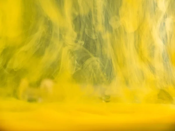 黄色のアクリル絵具は、抽象的な背景に水に落ちた。ビューを閉じます。背景がぼやけている。水の下で変換インク,抽象的なパターン.液体のインク、抽象的なバナーの背景. — ストック写真