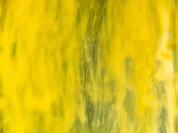 Fond jaune abstrait, vue rapprochée. Fond flou. Des gouttes de peinture jaune se dissolvent dans l'eau, motif abstrait. Encre transformant sous l'eau. Fond pour papier peint abstrait . — Photo