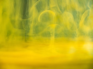 Soyut akrilik su altında akar, görünümü kapatın. Bulanık arka plan. Seçici yumuşak odak. Sıvı, soyut desen ile karıştırma sarı boya damlaları. Soyut duvar kağıdı ve afiş için arka plan.