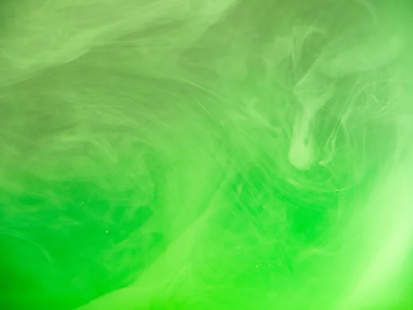 Humo acrílico verde bajo el agua, fondo abstracto. Vista de cerca. Fondo borroso. Ondas acrílicas verdes girando en forma líquida y abstracta. Mezcla de tinta con agua. Arte abstracto . —  Fotos de Stock