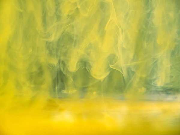 黄色のアクリルインクが水に落ち、抽象的なパターン。ビューを閉じます。背景がぼやけている。選択的ソフトフォーカス。水の下で抽象的な煙。抽象的な壁紙やバナーの背景. — ストック写真