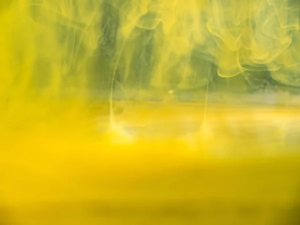 Humo acrílico abstracto bajo el agua. Vista de cerca. Fondo borroso. Enfoque suave selectivo. Nubes acrílicas amarillas disolviéndose en agua, patrón abstracto. Tinta moviéndose en fondo líquido, abstracto . —  Fotos de Stock