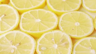 Sulu limon dilimleri, yakın çekim. Rotatif arka plan. Kesilmiş limon dilimleri deseni, soyut arka plan. Taze meyve bileşimi. Seçici yumuşak odak. Sanat enstalasyonu.
