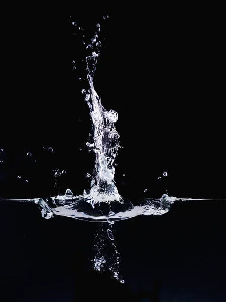 Explosão na superfície da água isolada em fundo preto, vista de perto. Bolhas subaquáticas e superfície ondulante. Fundo abstrato para o projeto de sobreposições, camada de modo de mistura de tela . — Fotografia de Stock