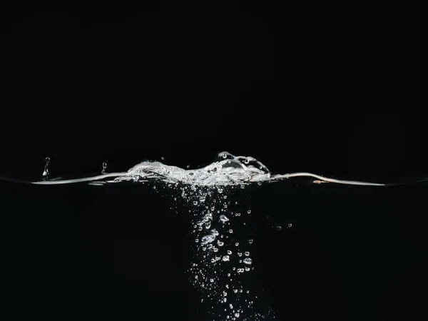 Bolhas de água e ondulação superfície da água isolada no fundo preto, vista de perto. Salpicos de líquido. Fundo abstrato para o projeto de sobreposições, camada de modo de mistura de tela . — Fotografia de Stock