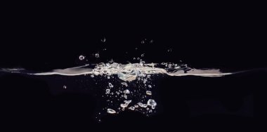 Su kabarcıkları ve siyah arka plan üzerinde izole sıvı yüzey dalgalanan, görünümü kapatın. Bindirmeler tasarımı, ekran karıştırma modu katmanı için soyut siyah arka plan.