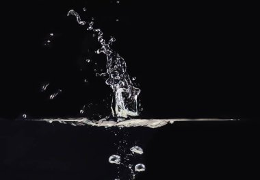 Siyah arka plan üzerinde izole su yüzeyinde patlama, yakın görüş. Su kabarcıkları su altında ve havada, bindirmeler tasarım için siyah arka plan, ekran karıştırma modu katmanı.