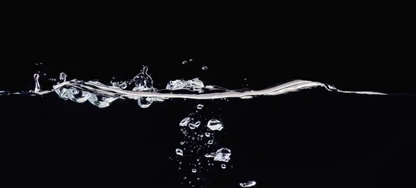 Rippling folyékony felszíni és a kis víz buborékok víz, elszigetelt fekete háttér, közelről kilátás. Absztrakt fekete háttér átfedések tervezése, képernyő keverési mód réteg. — Stock Fotó