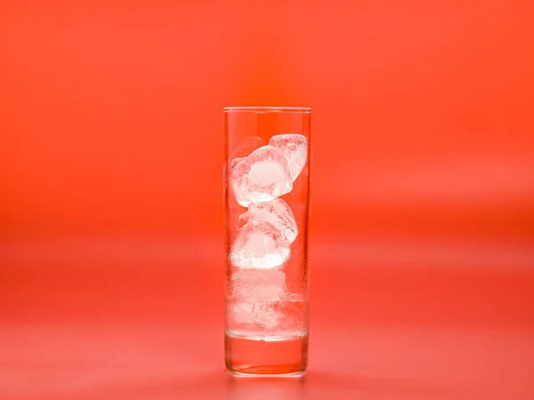 Cubos de hielo derritiéndose en vidrio sobre fondo rosa, vista de cerca. Agua sólida en vidrio. Condensar en la superficie del vidrio. Enfoque suave selectivo. Fondo borroso . —  Fotos de Stock