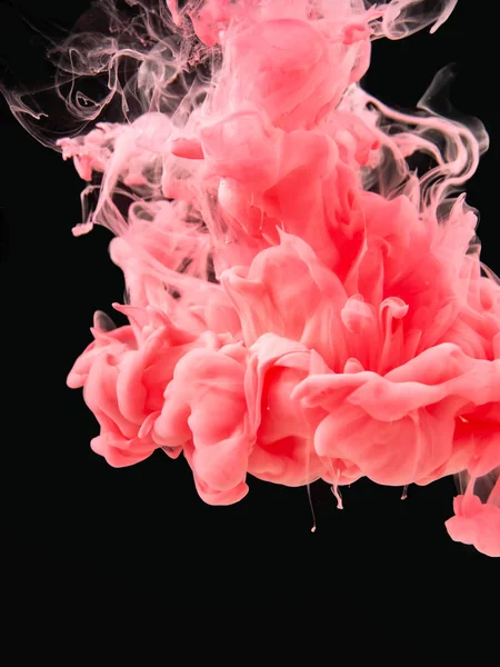 Πολύχρωμο ακρυλικό χρώμα κινείται υποβρύχια, απομονώνεται σε μαύρο φόντο, close up θέα. Ροζ ακρυλικό καπνό κινείται κάτω από το νερό. Αφηρημένο μαύρο φόντο για τη σχεδίαση επικαλύψεων, επίπεδο λειτουργίας ανάμειξης οθόνης. — Φωτογραφία Αρχείου