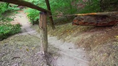 Tebeşir dağının kesik basamakları olan dağlardaki merdivenler. Dikkatli adımlarla bir el sanatları merdiveninden aşağı inin. Kişi görünümünden odaklanın. Tebeşir dağ yolu, orta plan. Adımların efektleri ile kamera taşıma