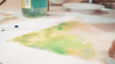 Kadın fırçaboya karışımları ve o kumaş boyalar. Kumaş üzerinde soyut desen, arka plan hazırlanması. Ev iğne simi yakın çekim. 