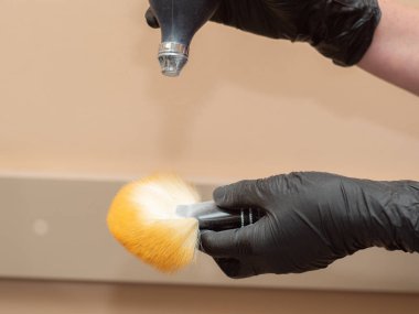 Kuaför kesilmiş saç müşterilerinin kafa temizlemek için sarı fırça talk pudrası koyar, görünümü kapatın. Sarı fırçalı siyah lastik eldivenler. Seçici yumuşak odak. Bulanık arka plan.