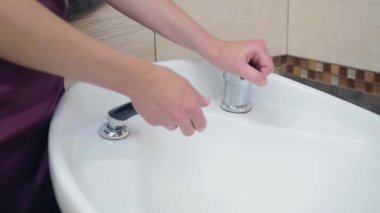 Stilist beyaz washstand, yakın çekim ellerini yıkama. Ellerin tıraş için yıkanması, kuaför salonuna kaydedilir. Berber dükkanının içi. Seçici yumuşak odaklama.