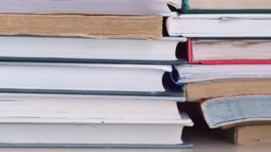 Dolly kitap rafı boyunca kayıyor. Kitaplar kitaplıktaki raflarda duruyor. Kapatın. Soldan sağa paralel hareket.