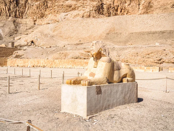 Ruined statue of androsphinx near Hatshepsut temple, medium view. Photographed in Luxor, Egypt. Selective soft focus. Blurred background.