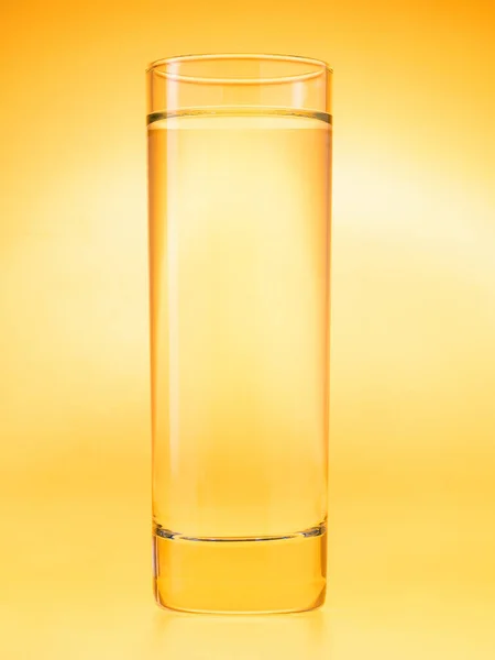 Καθαρό ποτήρι νερό σε κίτρινο φόντο. Μονόχρωμο χρωματικό σχέδιο. Φωτογραφία στούντιο. — Φωτογραφία Αρχείου