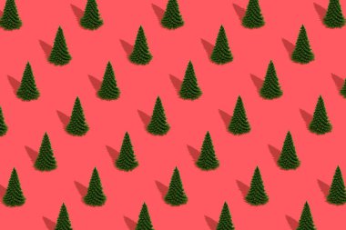 Kırmızı arka planda Noel ağaçlarının deseni. Yeni yıl konsepti. Moda kompozisyonu. 3d Görüntü