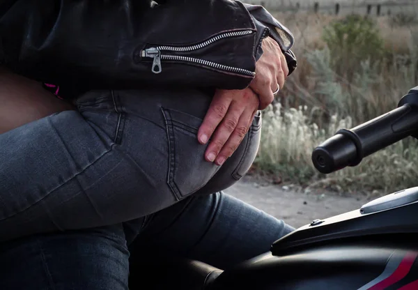 bir motosiklet üzerinde oturan bir bisikletçinin kadının geri sarılma bir motorcu adam elinde