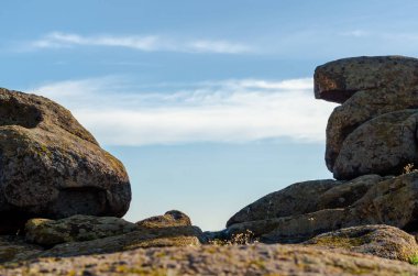 mavi bir gökyüzü ve beyaz bulutlar karşı büyük taşlar