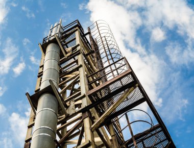 bir boru ve mavi bir gökyüzü ve bulutlar karşı bir merdiven ile kule