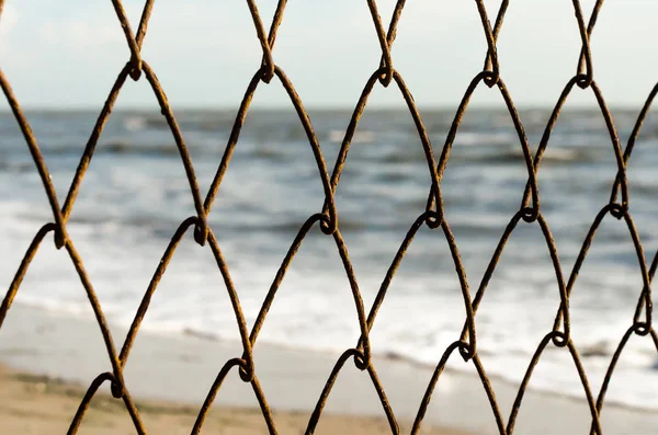 Maschendrahtzaun Auf Dem Hintergrund Des Strandes Und Des Meeres — Stockfoto