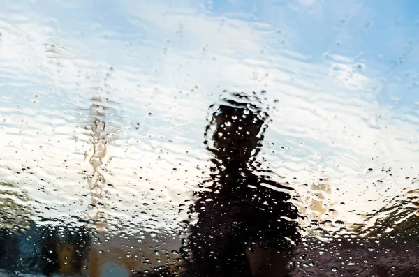 Tekstur air cuci mobil di kaca dengan orang di belakangnya — Stok Foto
