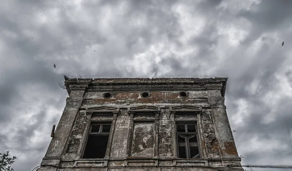 Distrutto vecchio edificio su un cielo cupo con uccelli — Foto Stock