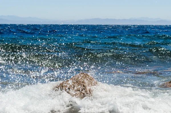 Wellen und Spritzer von Meeresbrandung und Steinen an der Küste in egy — Stockfoto